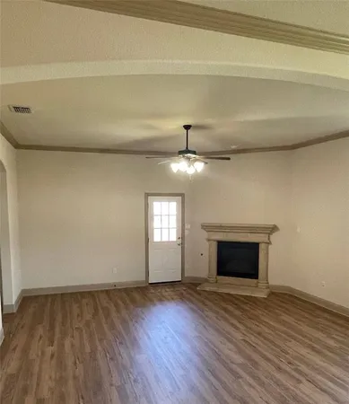 a view of an empty room with a fireplace and a window