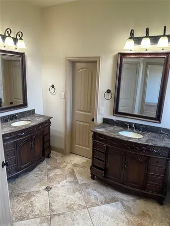 a spacious bathroom with a granite countertop sink and a mirror