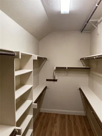 a view of walk in closet with empty racks