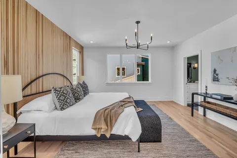 a bedroom with a bed and a dresser with mirror