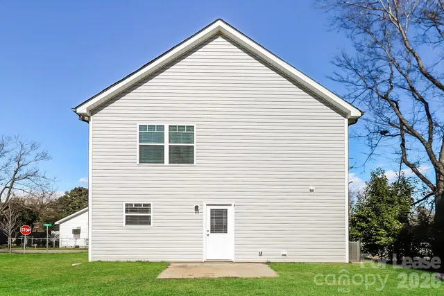 a view of a house with a yard and potted plants