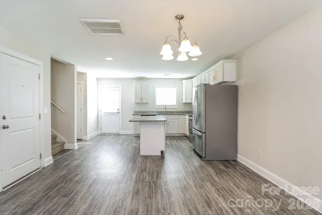 a kitchen with stainless steel appliances a refrigerator and wooden floor
