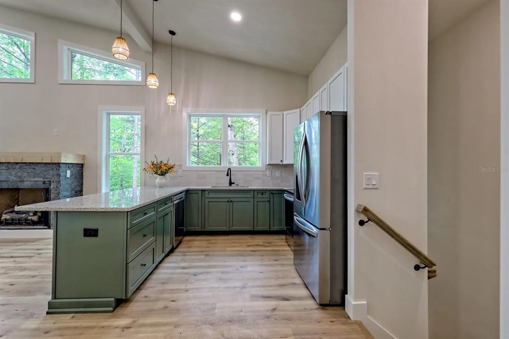 7810 Terrace Oaks Court Temple Terrace, FL 33617 - Photo 12 of 18 a kitchen with stainless steel appliances granite countertop a refrigerator a sink dishwasher a stove and a dining table with wooden floor