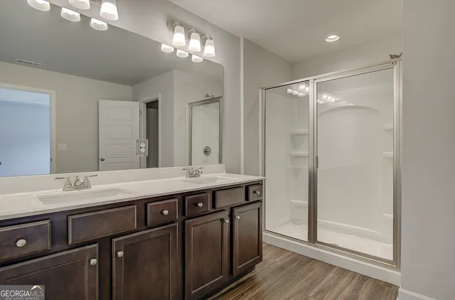 a bathroom with a double vanity sink mirror and shower