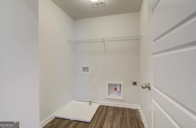 a sign board with a house in the background