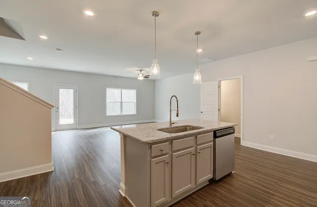 a kitchen with sink stove and wooden floor