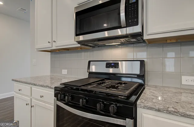 a stove top oven sitting inside of a kitchen
