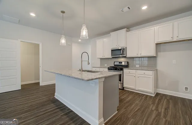 a kitchen with granite countertop a stove and a sink