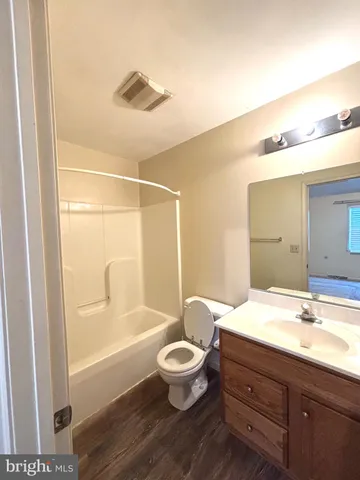 a bathroom with a bathtub shower sink vanity and toilet