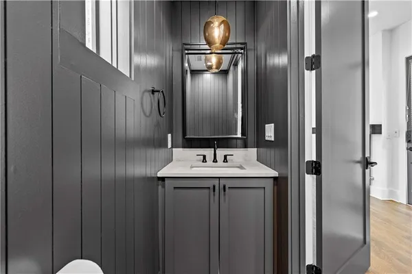 a view of an empty room with wooden floor and a ceiling fan