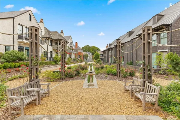 a view of a patio with table and chairs potted plants and large tree