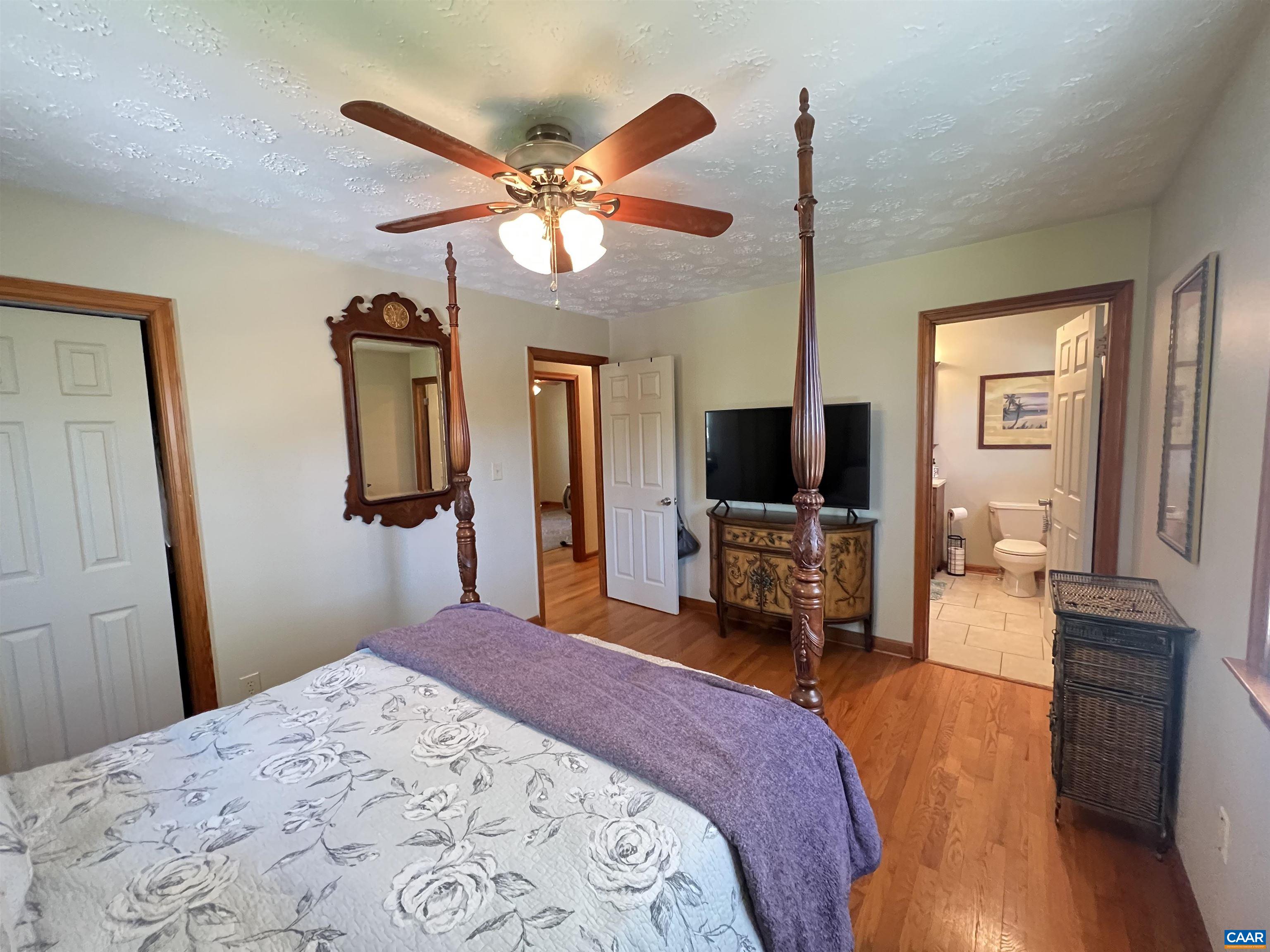 3515 Richmond Road Keswick, VA 22947 - Photo 17 of 47 a bedroom with a bed and a flat tv screen on dresser
