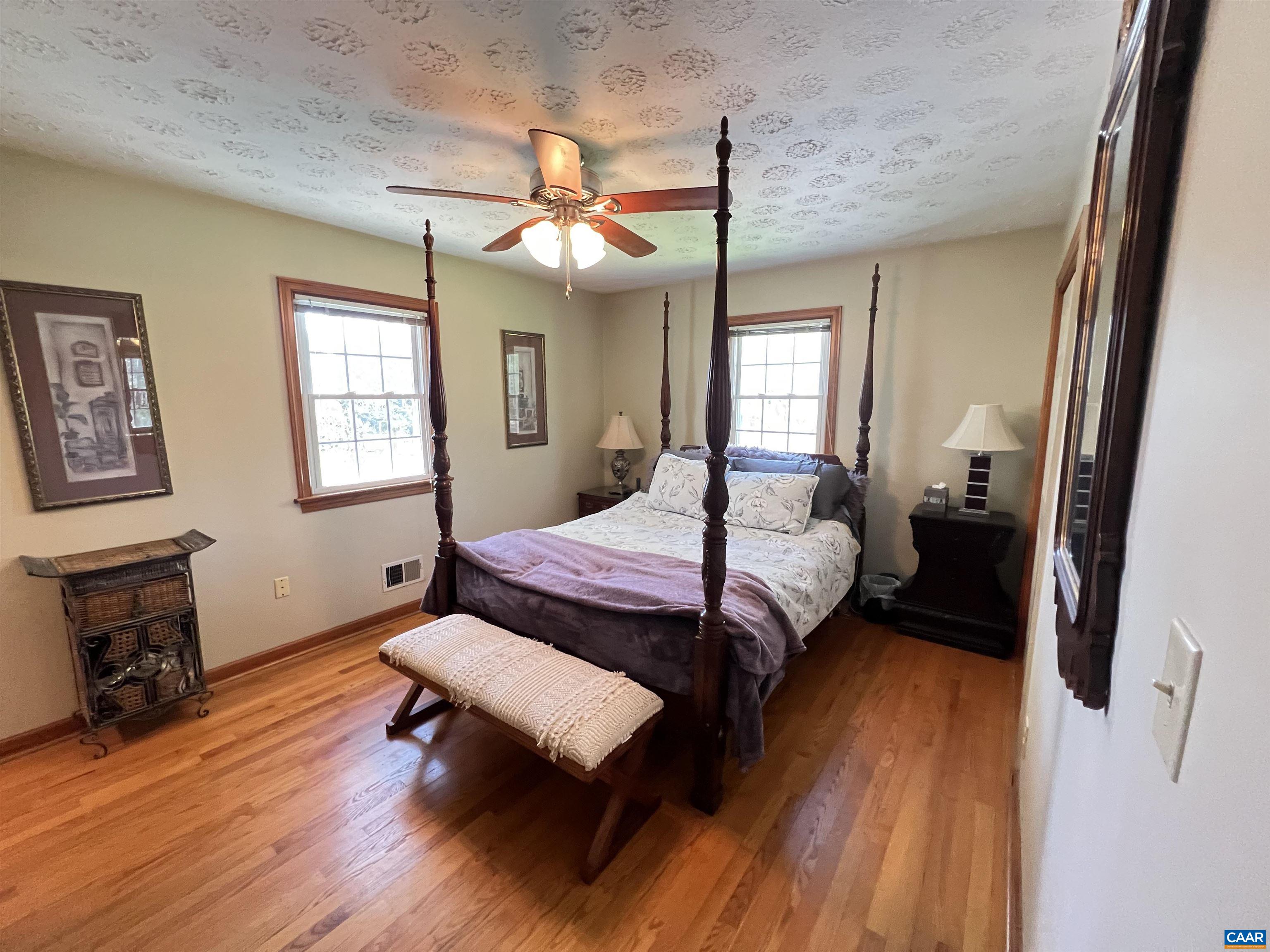 3515 Richmond Road Keswick, VA 22947 - Photo 18 of 47 a bedroom with a bed dresser and wooden floor