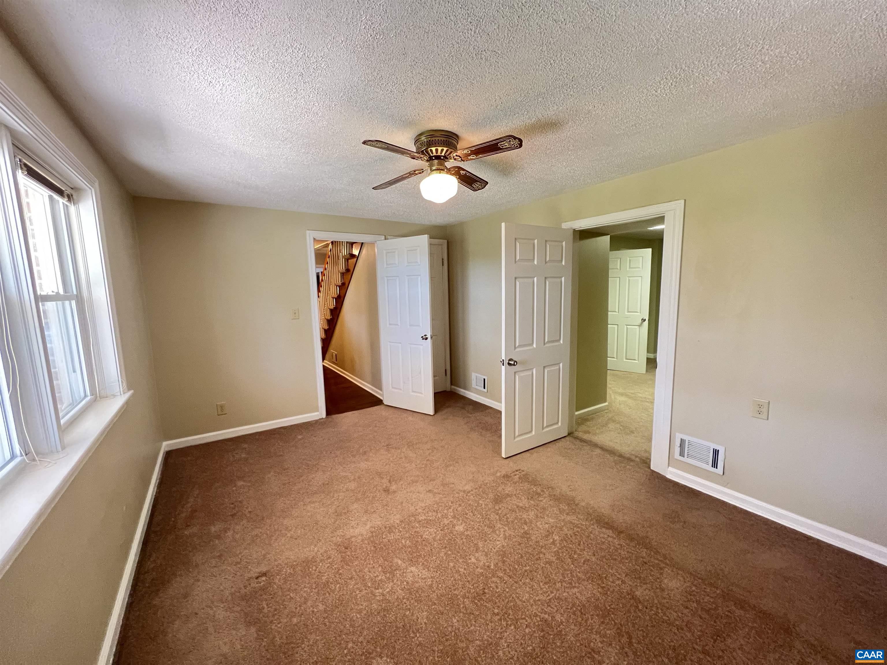 3515 Richmond Road Keswick, VA 22947 - Photo 29 of 47 an empty room with chandelier fan and windows