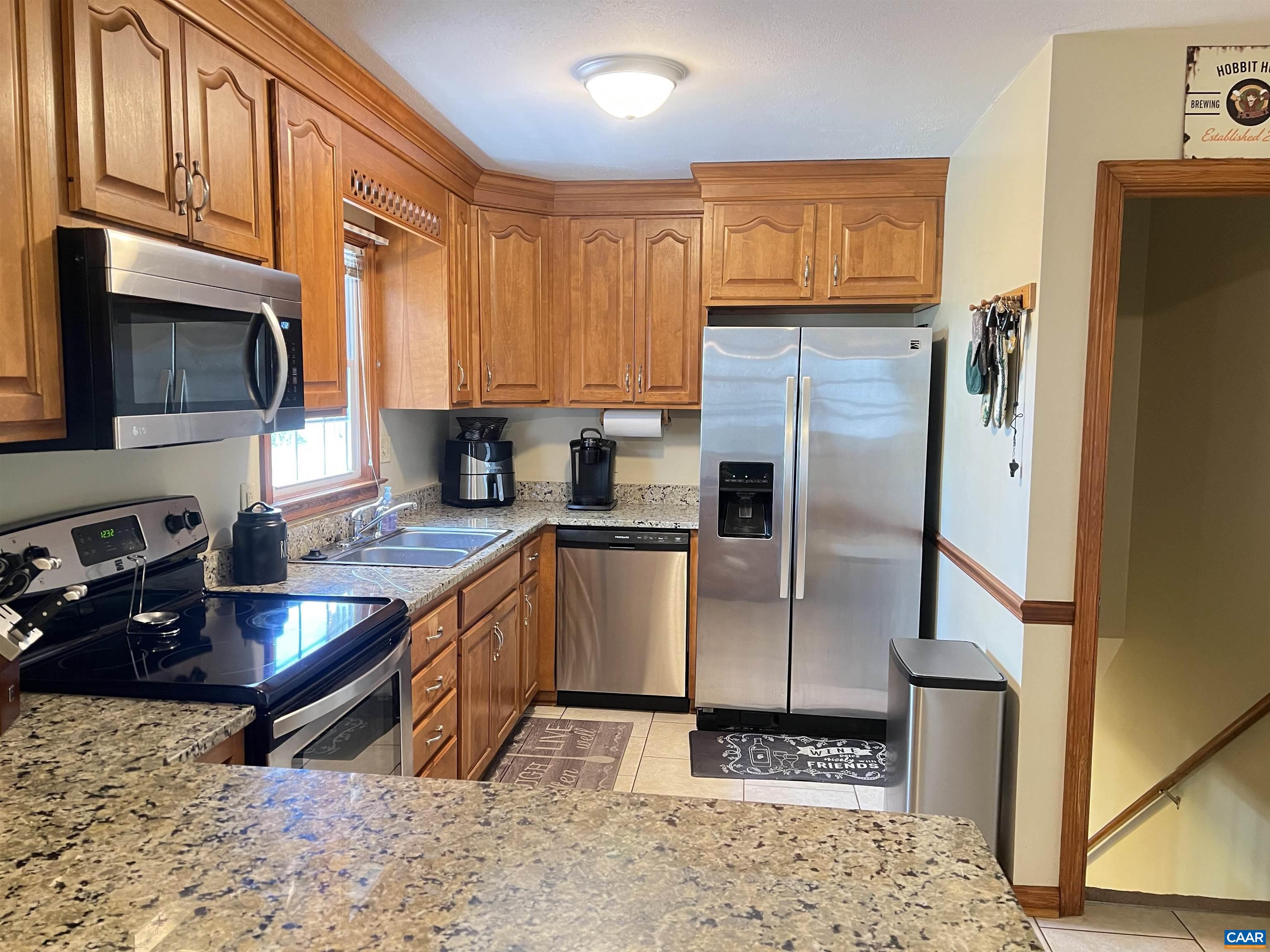 3515 Richmond Road Keswick, VA 22947 - Photo 9 of 47 a kitchen with stainless steel appliances granite countertop a refrigerator a stove and a sink with wooden cabinets