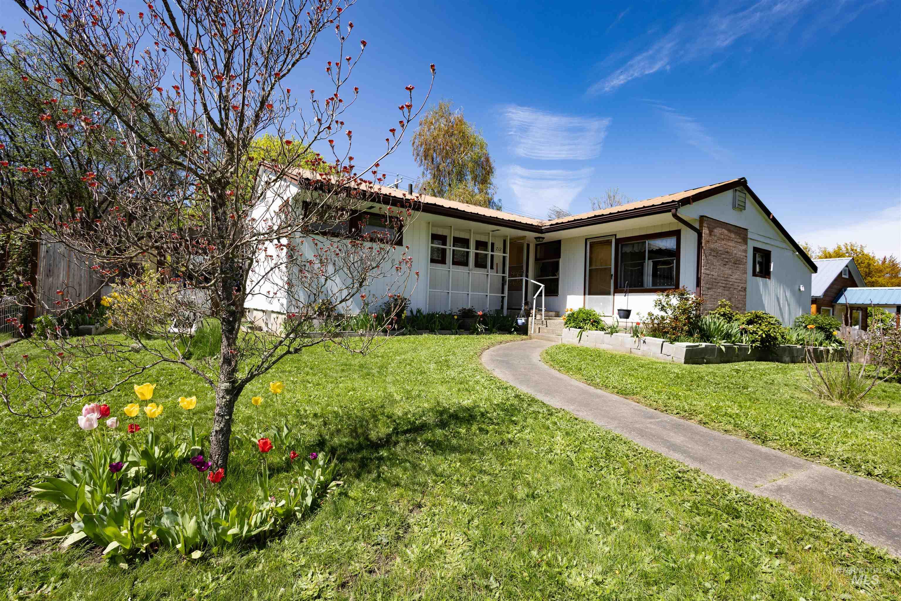 712 Hill Street Kamiah, ID 83536 - Photo 1 of 41 Manicured lawn with a curved concrete pathway leading to the front entry