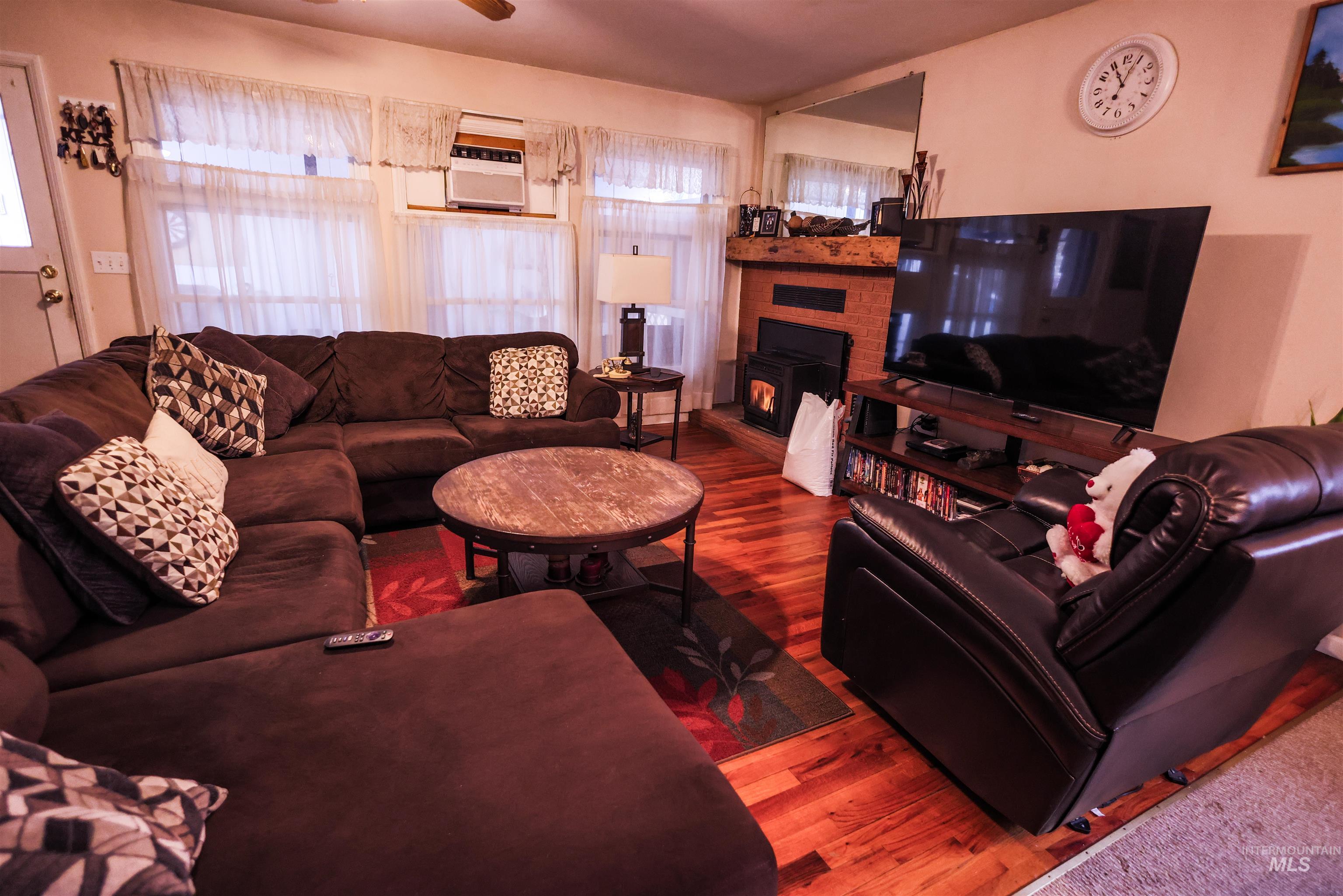 712 Hill Street Kamiah, ID 83536 - Photo 21 of 41 Living room featuring wood finished floors, a fireplace, and a ceiling fan