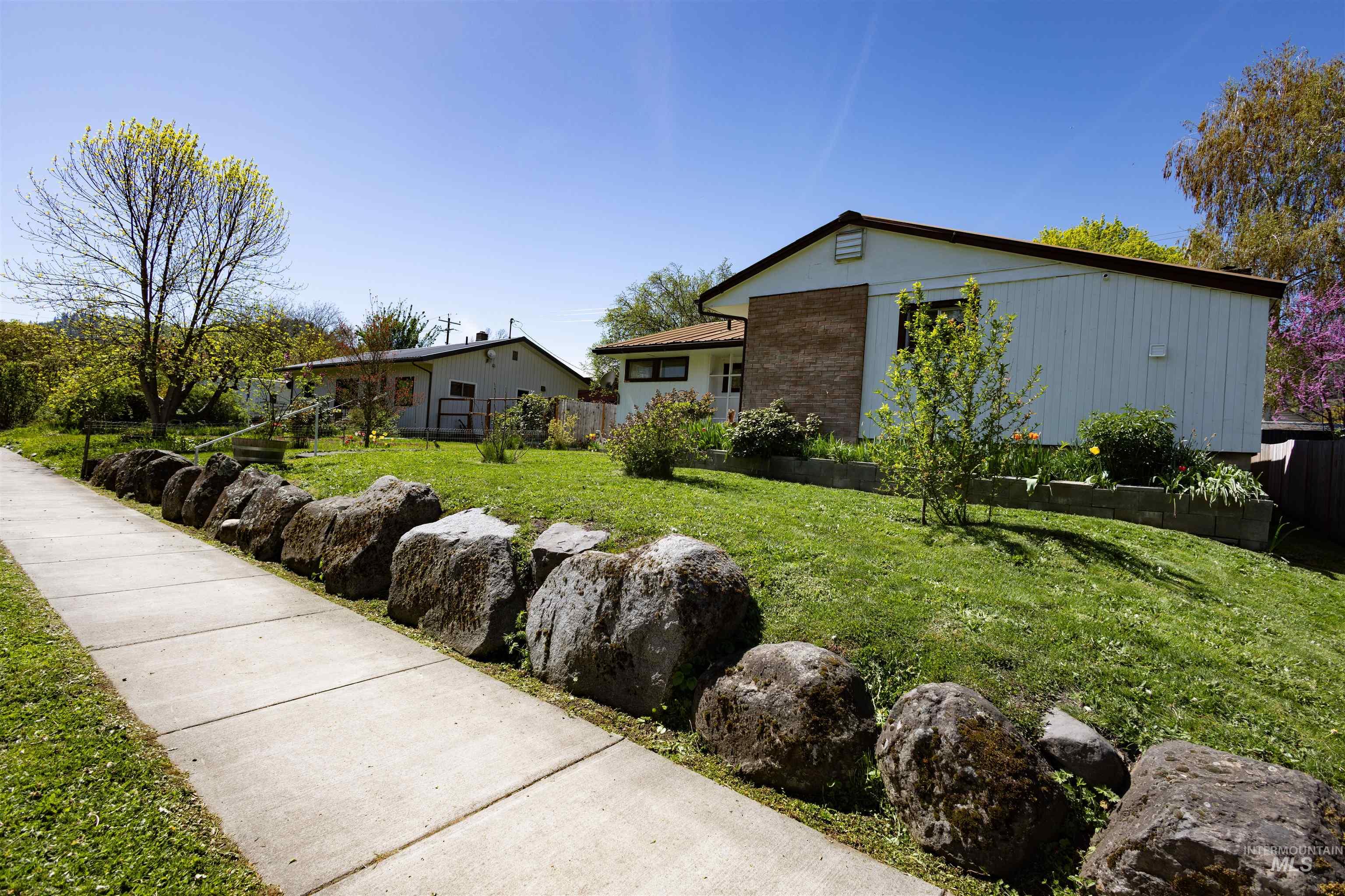 712 Hill Street Kamiah, ID 83536 - Photo 41 of 41 Sloping front yard featuring a concrete sidewalk, large natural rock retaining wall, and verdant green lawn