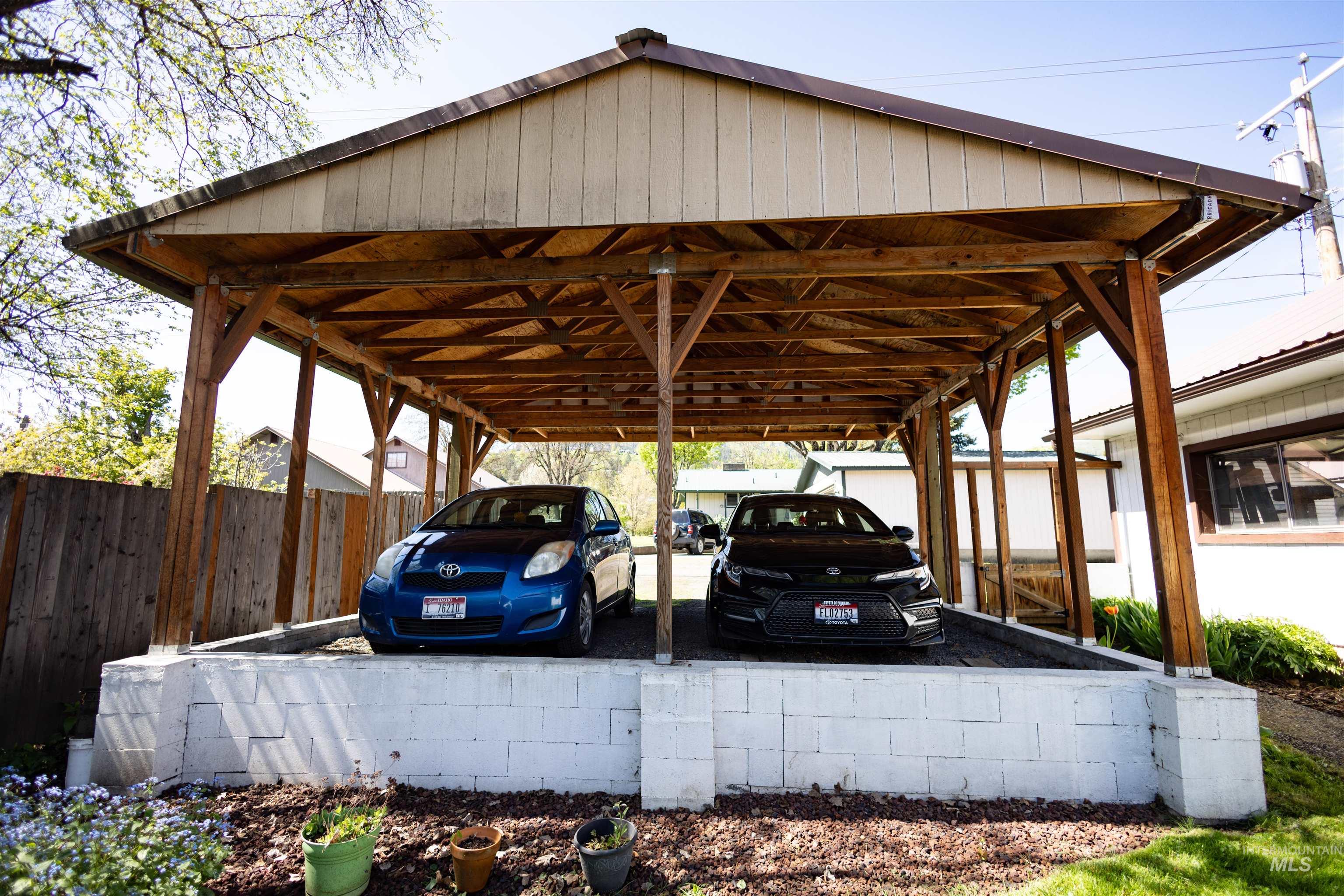 712 Hill Street Kamiah, ID 83536 - Photo 6 of 41 Carport structure featuring a pitched roof, exposed wood framing, and white concrete block retaining walls