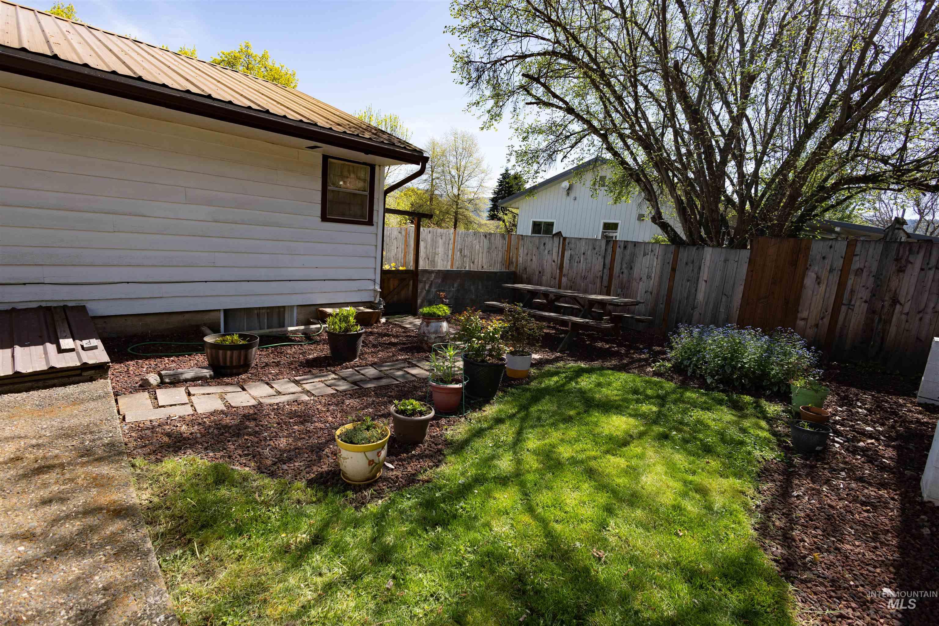 712 Hill Street Kamiah, ID 83536 - Photo 10 of 41 Fenced backyard featuring a mix of manicured lawn, mulched areas, and a stone paver path
