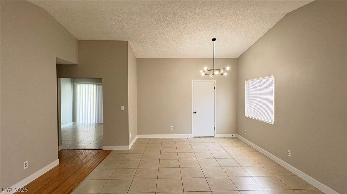 4325 Newcastle Road Las Vegas, NV 89103 - Photo 6 of 18 A versatile open-concept living space features stylish mixed flooring and contemporary lighting.