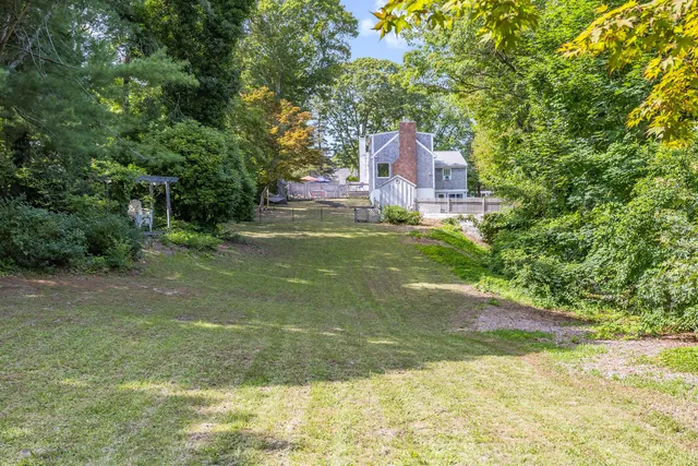 a view of backyard with swimming pool and green space