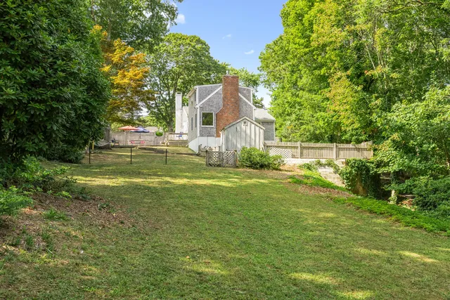 a backyard of a house with a small yard and large tree