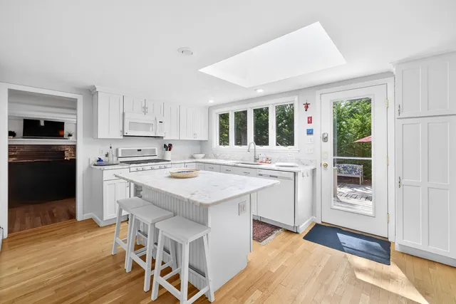 a kitchen with granite countertop a stove a sink and a refrigerator