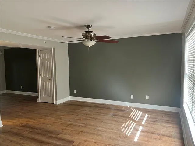 a view of a livingroom with a chandelier fan and windows