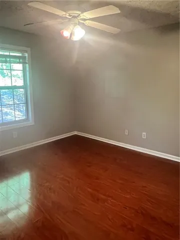 an empty room with wooden floor and windows in it
