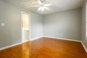 an empty room with a chandelier fan and windows