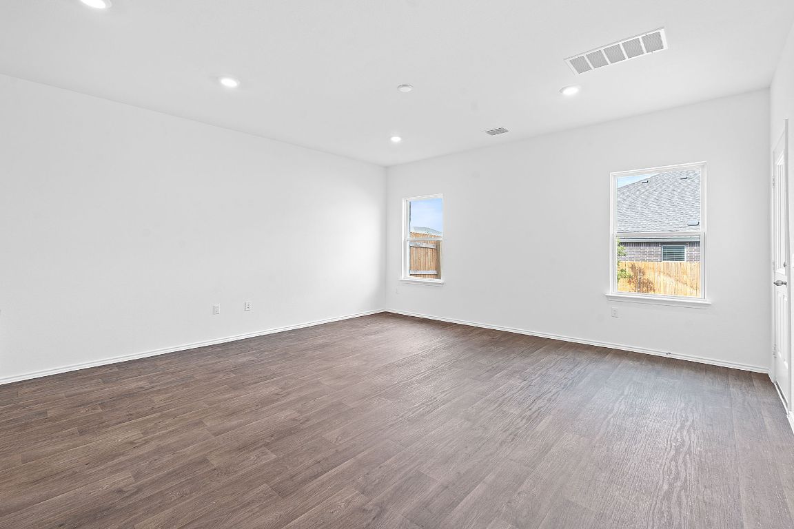 18500 B Empire Path Manor, TX 78653 - Photo 12 of 31 Spare room featuring dark wood-style flooring, healthy amount of natural light, and recessed lighting