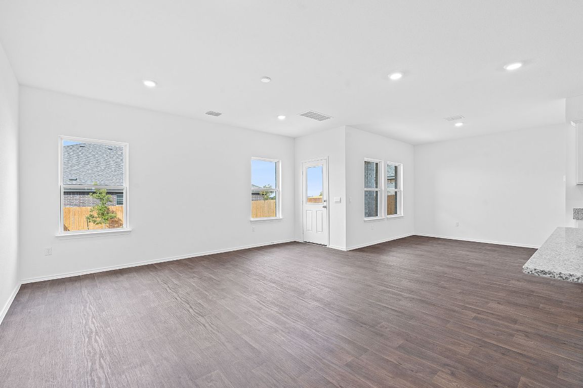 18500 B Empire Path Manor, TX 78653 - Photo 13 of 31 Empty room featuring dark wood-style flooring and recessed lighting