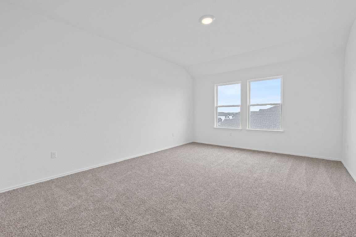 18500 B Empire Path Manor, TX 78653 - Photo 20 of 31 Empty room featuring lofted ceiling, carpet, and recessed lighting