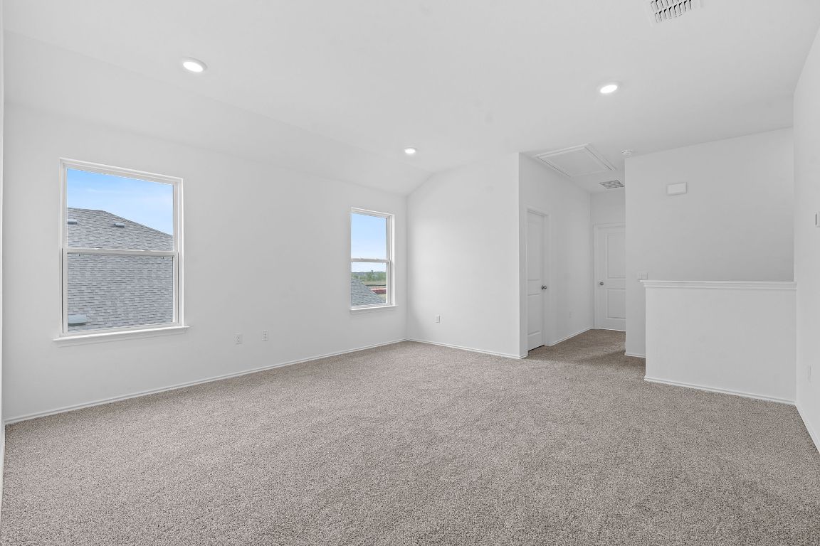 18500 B Empire Path Manor, TX 78653 - Photo 24 of 31 Spare room with light colored carpet, recessed lighting, and lofted ceiling