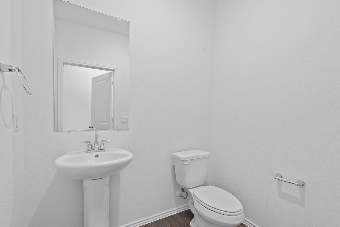 18500 B Empire Path Manor, TX 78653 - Photo 26 of 31 Half bath featuring baseboards and dark wood-type flooring