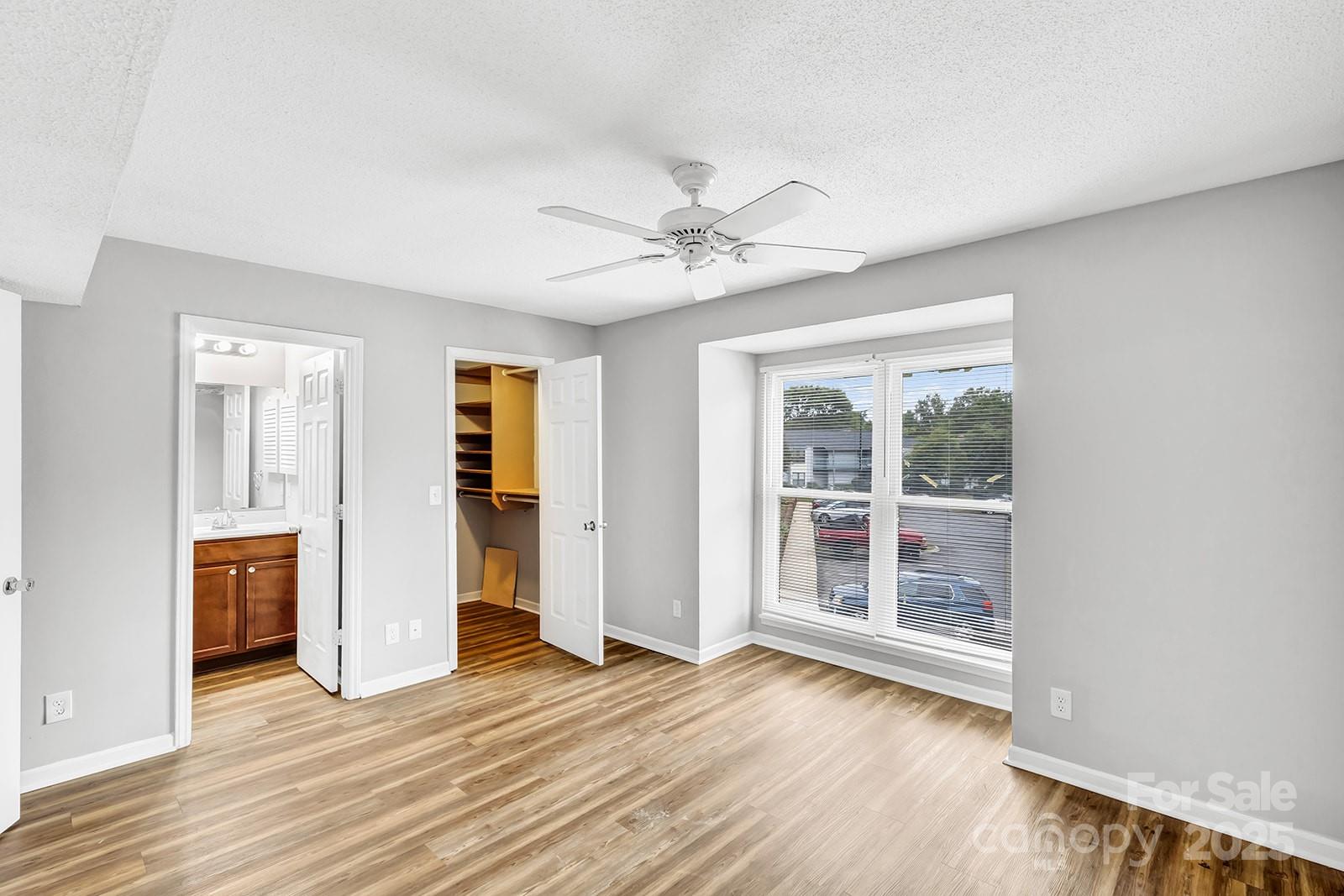 11015 Harrowfield Road Charlotte, NC 28226 - Photo 11 of 28 an empty room with wooden floor and ceiling fan