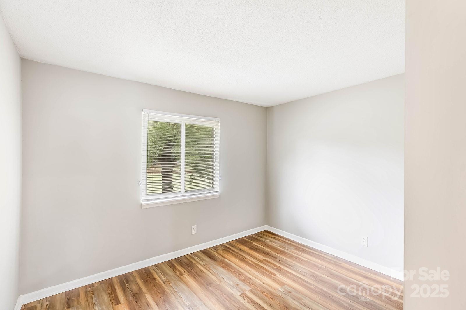 11015 Harrowfield Road Charlotte, NC 28226 - Photo 13 of 28 a view of an empty room with wooden floor and a window