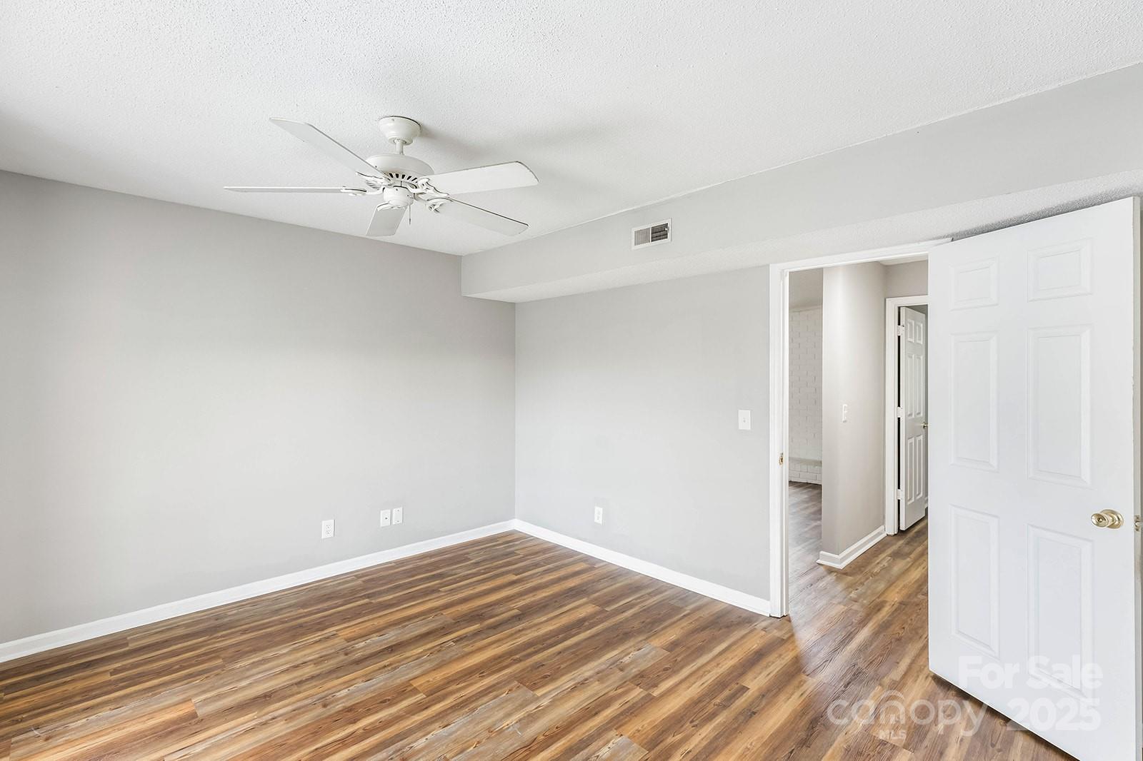 11015 Harrowfield Road Charlotte, NC 28226 - Photo 14 of 28 a view of a room with wooden floor and ceiling fan