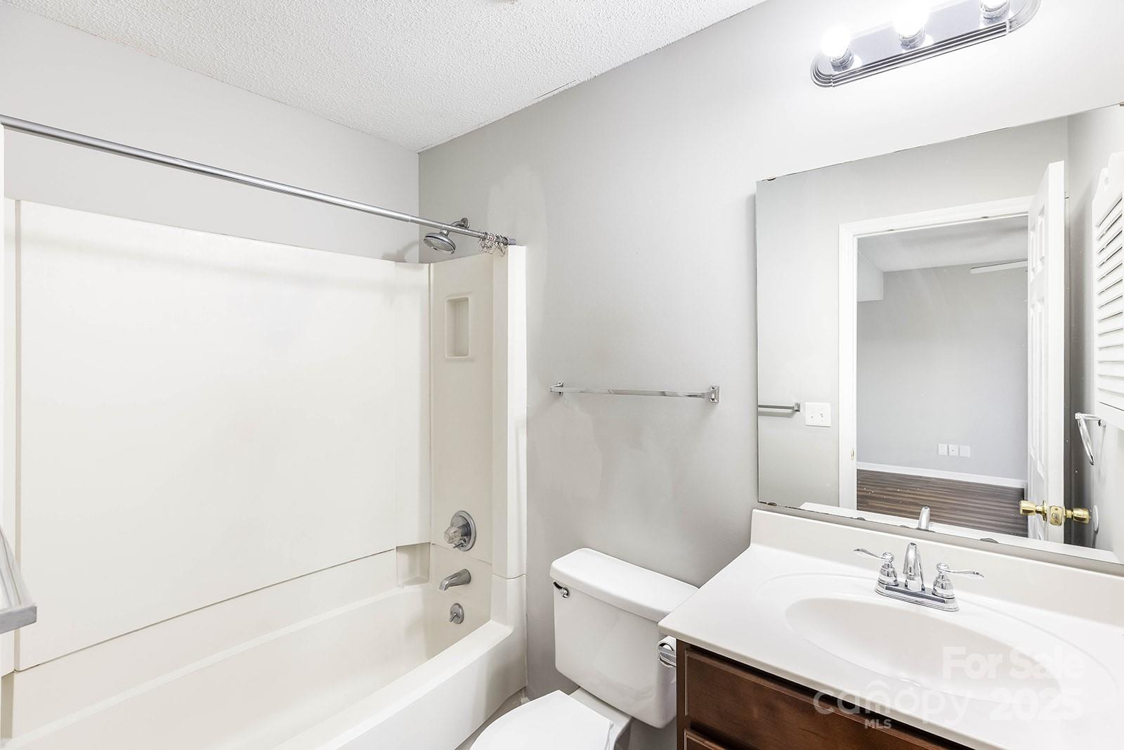 11015 Harrowfield Road Charlotte, NC 28226 - Photo 16 of 28 a bathroom with a bathtub shower sink vanity and toilet