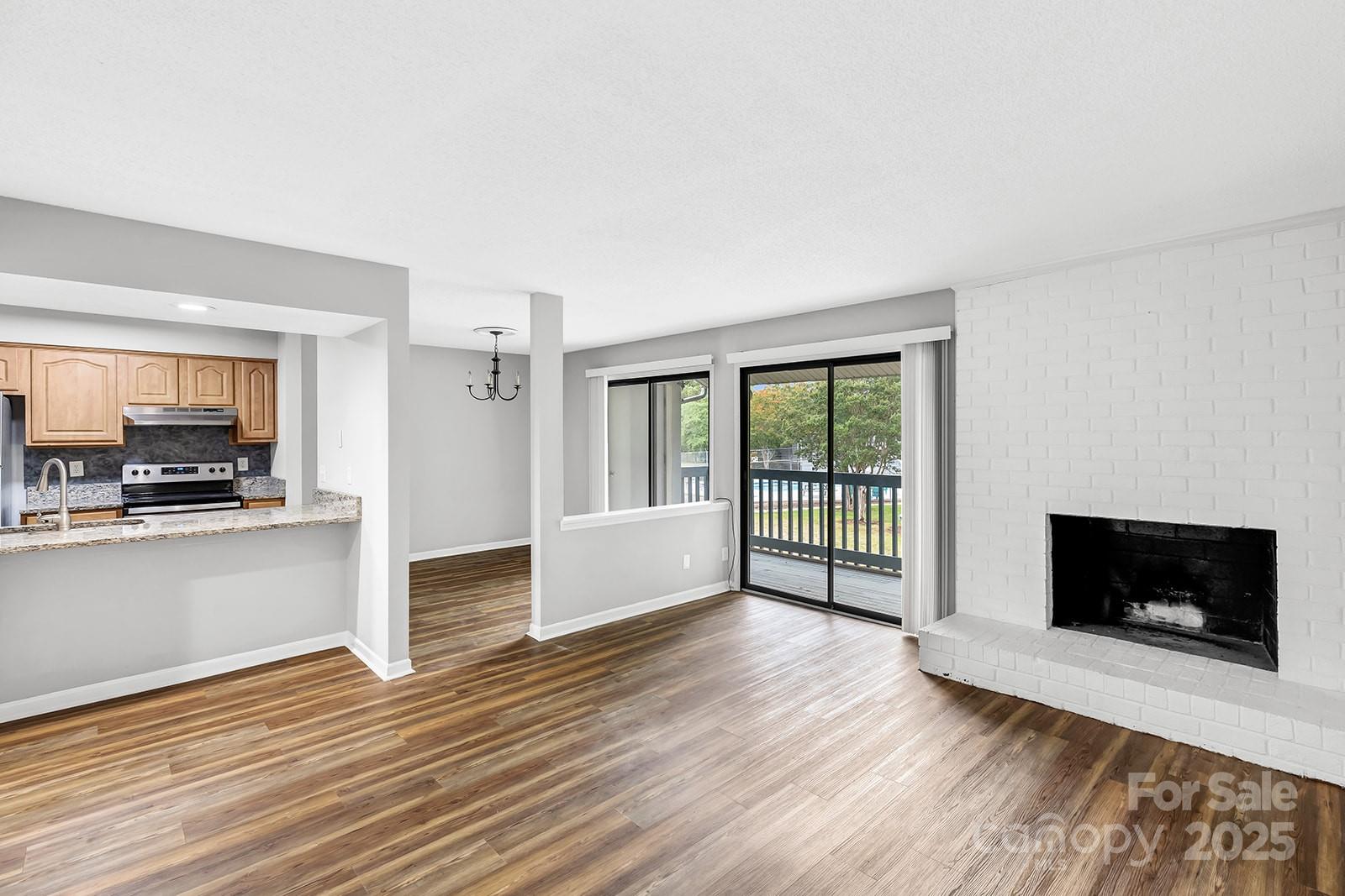 11015 Harrowfield Road Charlotte, NC 28226 - Photo 2 of 28 a view of a livingroom with wooden floor and a fireplace