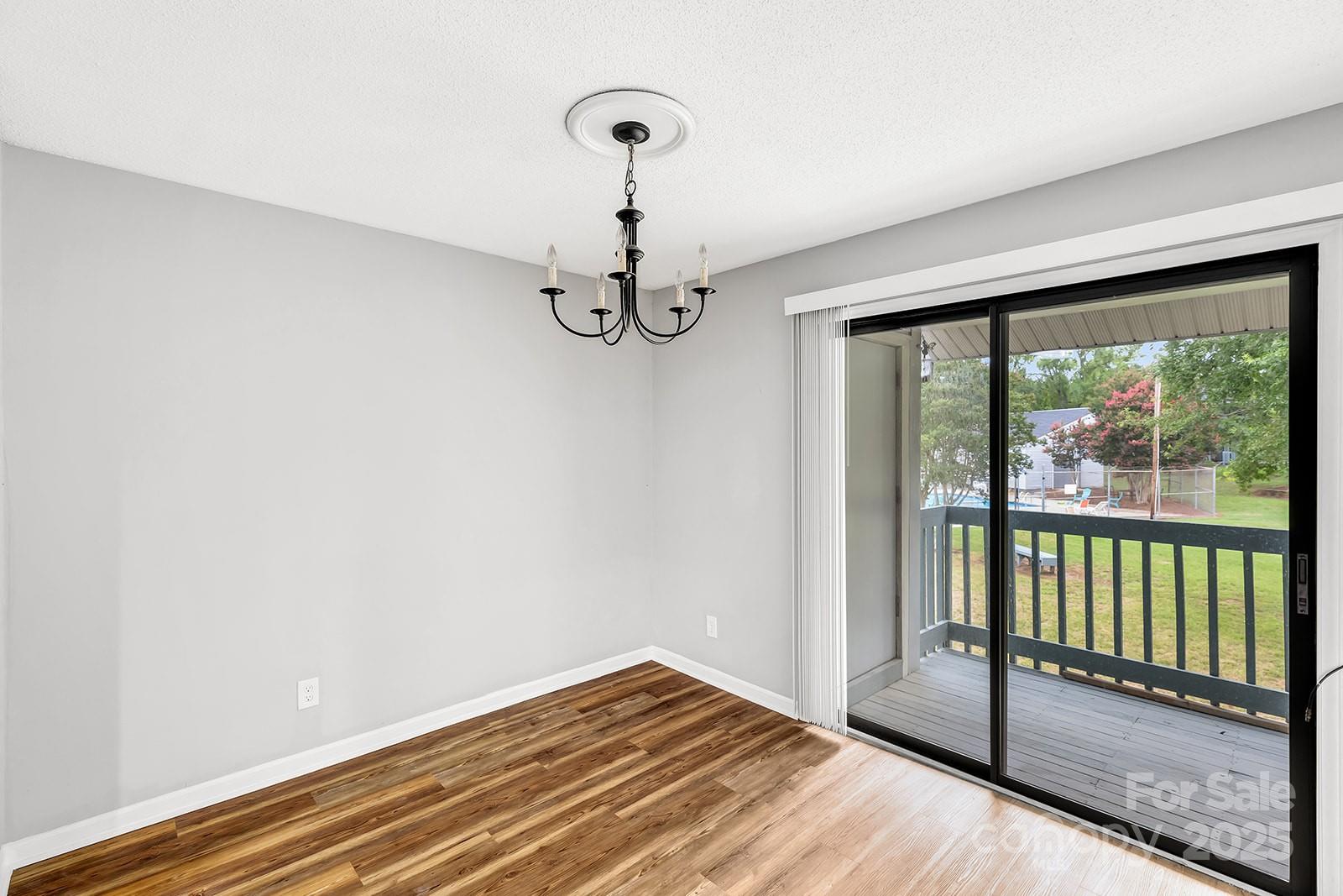11015 Harrowfield Road Charlotte, NC 28226 - Photo 4 of 28 a view of empty room with wooden floor and fan