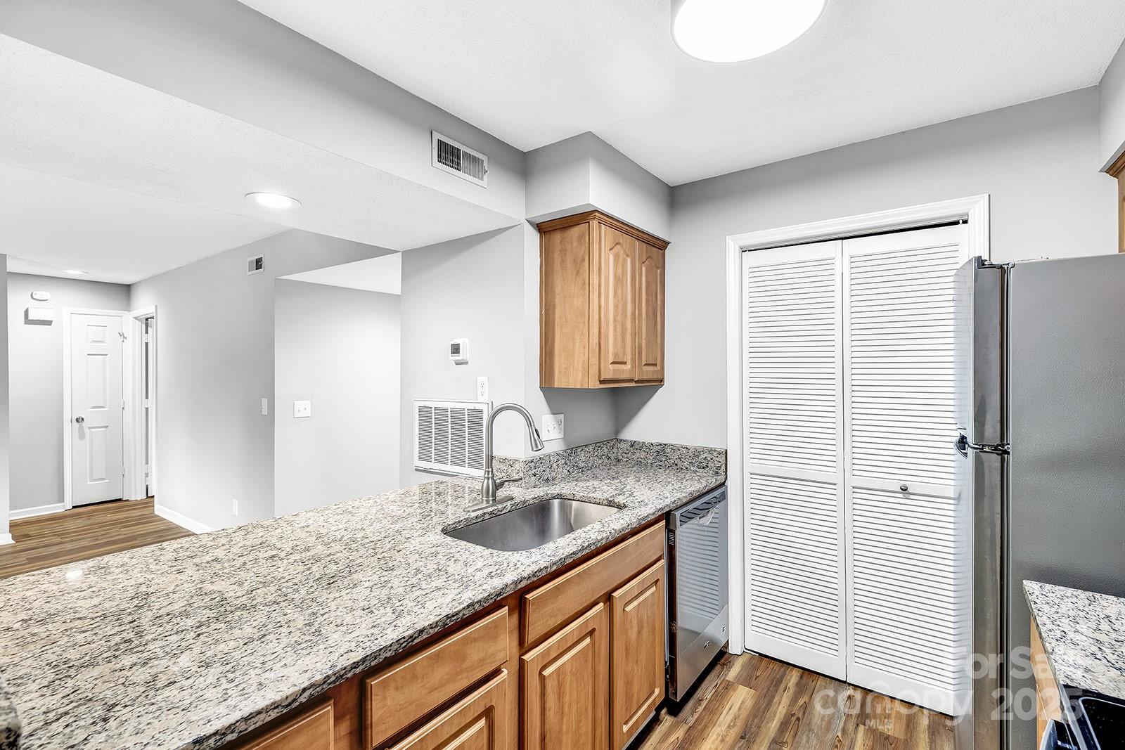 11015 Harrowfield Road Charlotte, NC 28226 - Photo 10 of 28 a kitchen with stainless steel appliances granite countertop cabinets and wooden floor