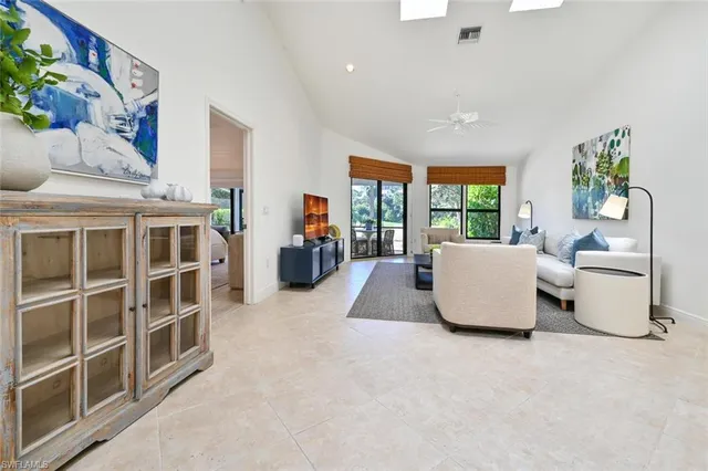 a living room with furniture and a floor to ceiling window