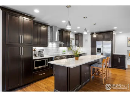 a kitchen with kitchen island granite countertop stainless steel appliances and sink