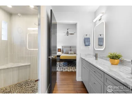 a en suite bathroom with a granite countertop sink and a mirror