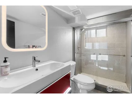 a bathroom with a sink toilet a mirror and shower