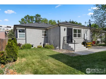 a front view of a house with a yard and potted plants