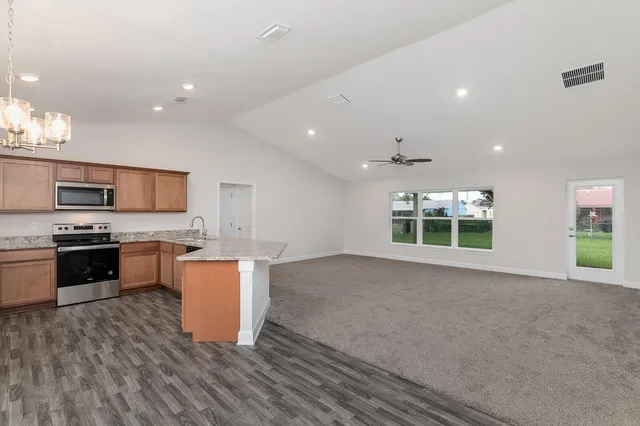 a kitchen with stainless steel appliances granite countertop a sink stove and microwave