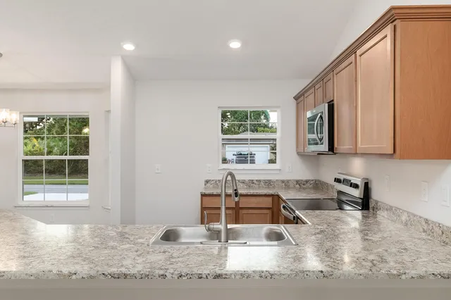 a kitchen with stainless steel appliances granite countertop a sink stove and microwave